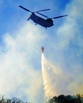 空中消火活動を行う自衛隊のCH-47大型輸送ヘリコプター。
バンビバケットという消火機材を使って1回で5tもの散水ができる