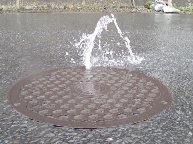 内水氾濫によりマンホールから水が溢れ出る様子