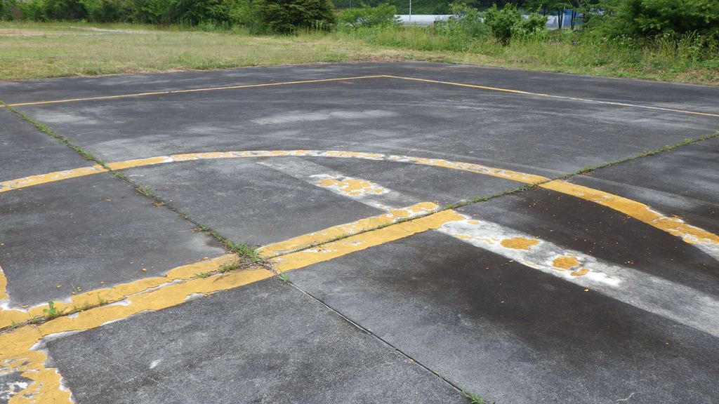 例1 某場外離着陸場の離着陸地帯標識は溶融塗料で描かれており、剥離している。